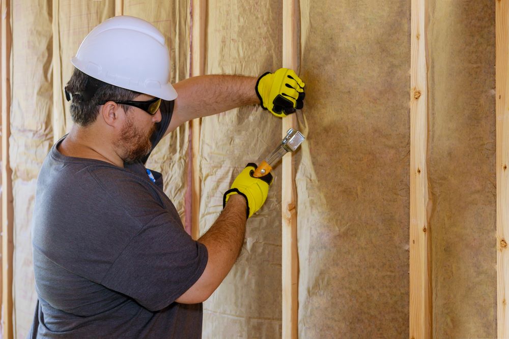 Artisan qui installe un insolant sur un mur